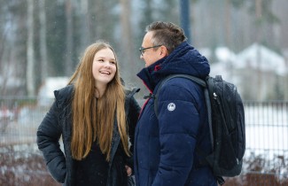 Nuori tytär ja isä keskustelevat hyvän tuulisina talvisäässä.