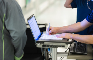 Sote-ammattilainen kirjaa asiakastietoja koneelle.