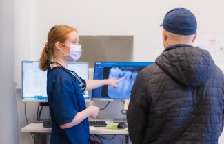 Ammattilainen näyttää asiakkaalle röntgenkuvaa hampaista.