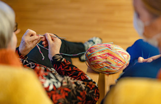 Henkilö kutoo villalangalla.