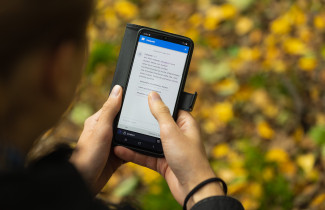 Sähköistä sosiaali- ja terveyspalvelujen asiointia matkapuhelimella ulkona.