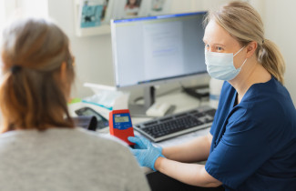 Hoitotyöntekijä mittaa potilaalta verensokeriarvon