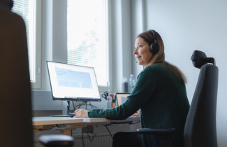 Sosiaaliohjaaja istuu tietokoneen ääressä
