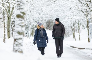 Kaksi henkilöä ulkoilemassa lumisessa maisemassa