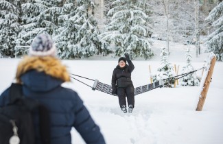 Ikääntynyt ulkoilija vilkuttaa riippukeinusta ystävälle