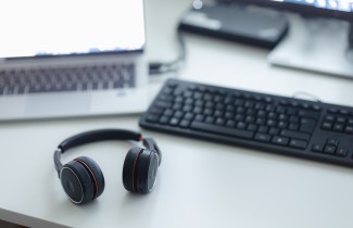 Kuulokkeet, näppäimistö ja kannettava tietokone