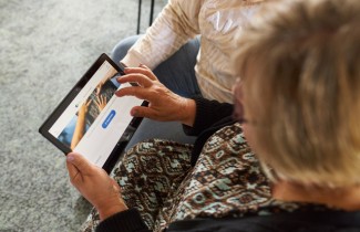 Kuvassa henkilö tutkii tabletilta digipalveluita.