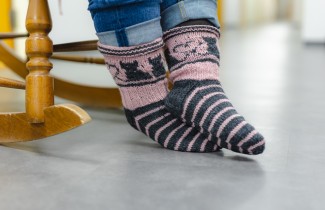 Villasukat keinutuolissa istuvan ihmisen jaloissa