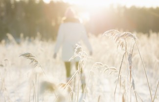 Henkilö kävelemässä rannalla talvella aurinkoisella säällä