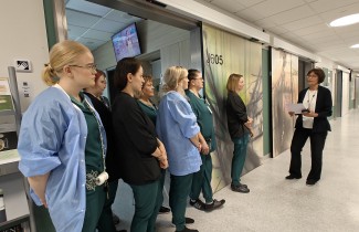 Sairaala Novan kotiutusyksikön työntekijät ovat kokoontuneet käytävälle ottamaan vastaan diplomin Kirsi Piitulaiselta.