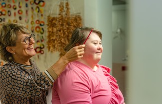 Keski-Suomen hyvinvointialueen ammattilainen kampaa asiakkaan hiuksia. 