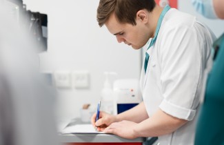 Päivystyksen ammattilainen kirjaa potilaan tietoja muistiin.