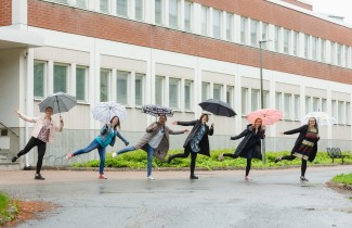 Ihmisiä ulkona sateenvarjojen kanssa.