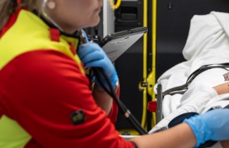 Ensihoitaja ambulanssissa stetoskooppi korvilla