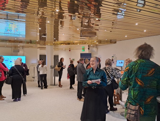 Ihmisiä keskustelemassa aulatilassa.