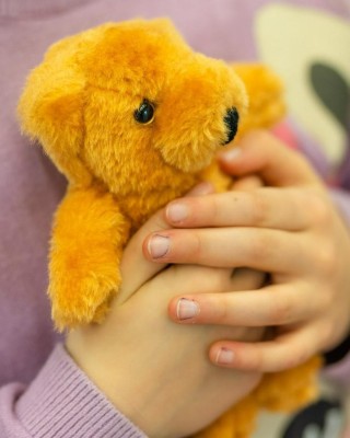 Lapsi pitämässä nallea sylissään.