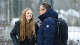 Nuori tytär ja isä keskustelevat hyvän tuulisina talvisäässä.