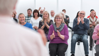 Yleisö taputtaa esiintyjälle.