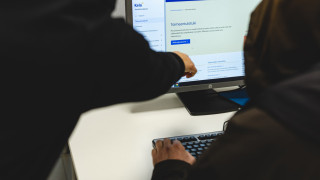 Sosiaaliohjaaja opastaa asiakasta löytämään tietoa verkkosivuilta.