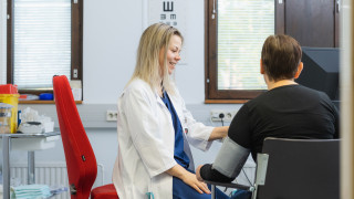 Lääkäri mittaa verenpaineen asiakkaalta.