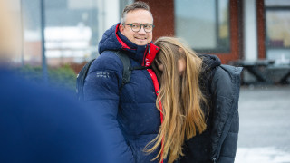 Aikuinen ja nuori seisomassa vierekkäin ulkona.