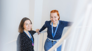 Työkaverit juttelevat portaikossa