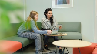 Nuori ja aikuinen istuvat sohvalla, juttelevat ja katsovat Mun stoori-kortteja.