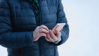 Henkilö kädessään matkapuhelin.