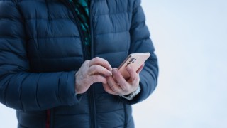 Mies tarkistaa puhelimella pankkitilinsä saldoa