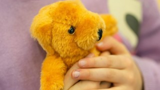 Lapsi pitämässä nallea sylissään.