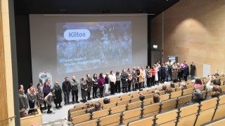 Hanketyöntekijät auditorion edessä.