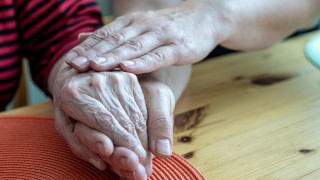 Käsi ikäihmisen kädellä 