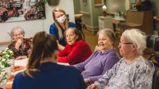 Ikäihmiset yhteisen pöydän ääressä