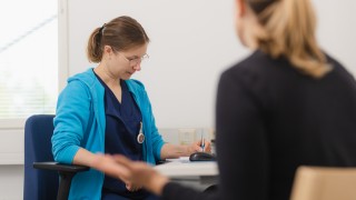 Hoitaja ja asiakas istuvat vastatusten