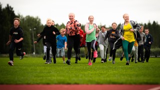 Iloisia lapsia urheilukentällä.