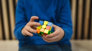 Lapsi pelaa Rubikin kuutio -peliä.