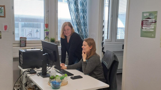 Kaksi työntekijää tietokoneen äärellä.