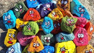 Ilmeikkääksi maalattuja hyvän mielen kiviä.