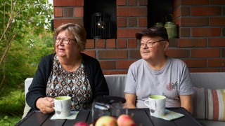 Iäkäs pariskunta istuu kotinsa terassilla.