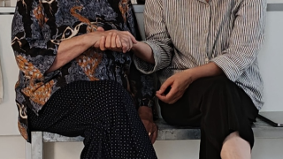 Kaksi ihmistä käsi kädessä.