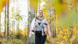 Nainen kävelee syksyisessä metsässä.