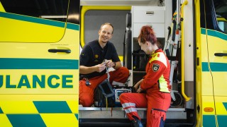 Ensihoidon ammattilaiset ambulanssin vieressä.