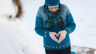 Henkilö tekee käsillään sydämen.