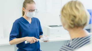 Hoitaja palvelee asiakasta.